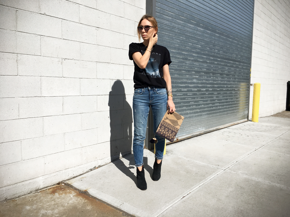 Woman posing for outfit photo in jeans and printed tee