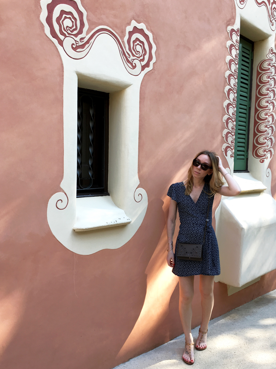 Woman posing in dress in front of pink house