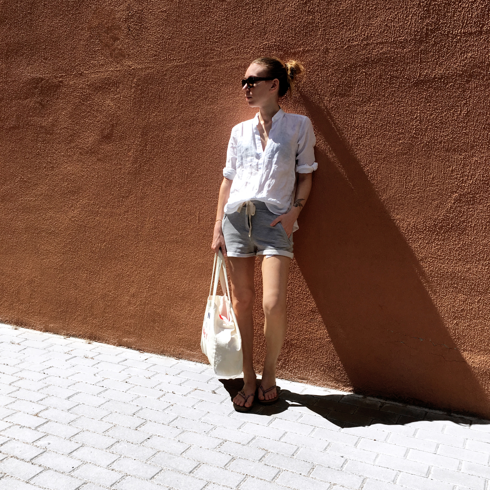 Woman posing against orange colored wall